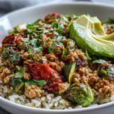 Hearty Ground Turkey Bowl features juicy, spice-rubbed turkey piled atop roasted broccoli, bell peppers, and zucchini, served with zesty lime wedges.
