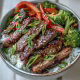 Quick homemade Teriyaki Beef Bowl garnished with fresh green onions and toasted sesame seeds.