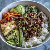 Hearty Korean ground beef bowl served with cauliflower rice and crisp pickled carrots, cucumber, and radish.  