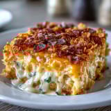 Baked hash brown casserole loaded with sharp cheddar, savory onions, and crispy cornflake crust.