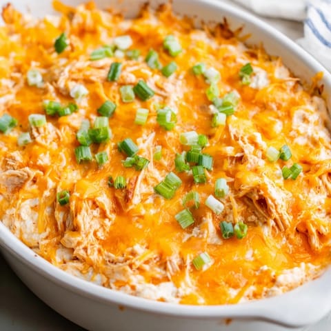 Golden, bubbly Buffalo Chicken Dip served with crisp celery and crunchy tortilla chips.