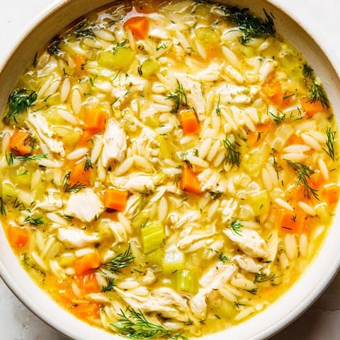 Lemon-scented Chicken Lemon Orzo Soup served with crusty bread for dipping.