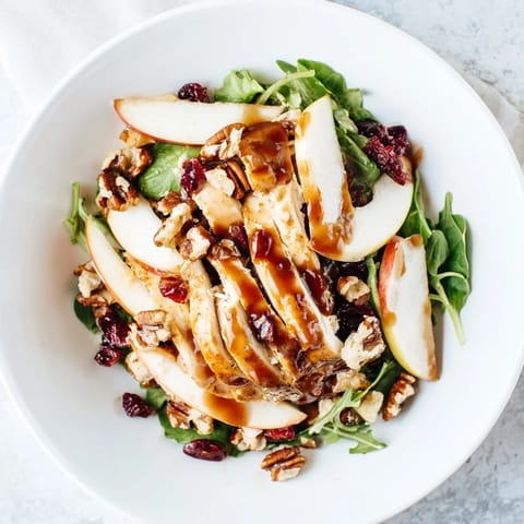 Caramel Apple Chicken Salad showcases tender chicken slices and crisp apple wedges on mixed greens with caramel-pecan dressing.
