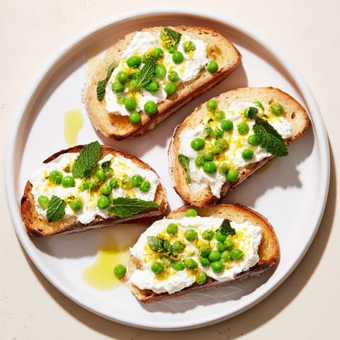Golden, crispy sourdough slices generously topped with bright green Pea & Mint Ricotta Toast, finished with fresh lemon zest.