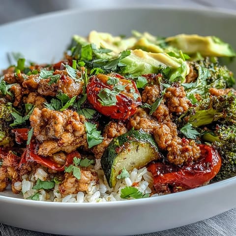 Ground Turkey Bowl with seasoned meat, vibrant roasted vegetables, and fluffy brown rice, all garnished with fresh cilantro and avocado slices.