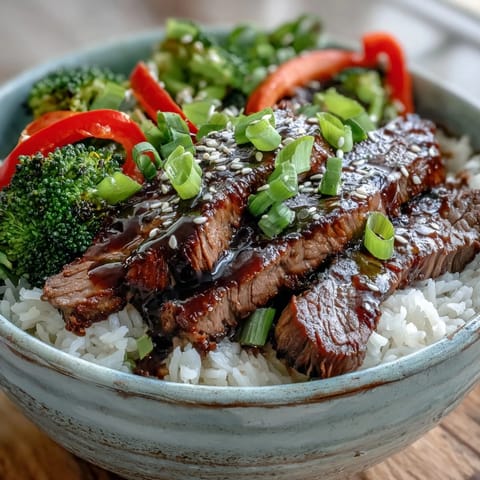 Steamed rice topped with glossy teriyaki beef and vibrant sautéed vegetables for an easy weeknight meal.