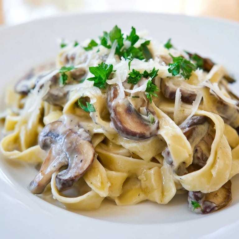 Creamy mushroom alfredo tossed with fettuccine, featuring sautéed cremini mushrooms and garlic in a velvety sauce.