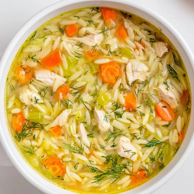 Homemade Chicken Lemon Orzo Soup in a rustic bowl, garnished with parsley.