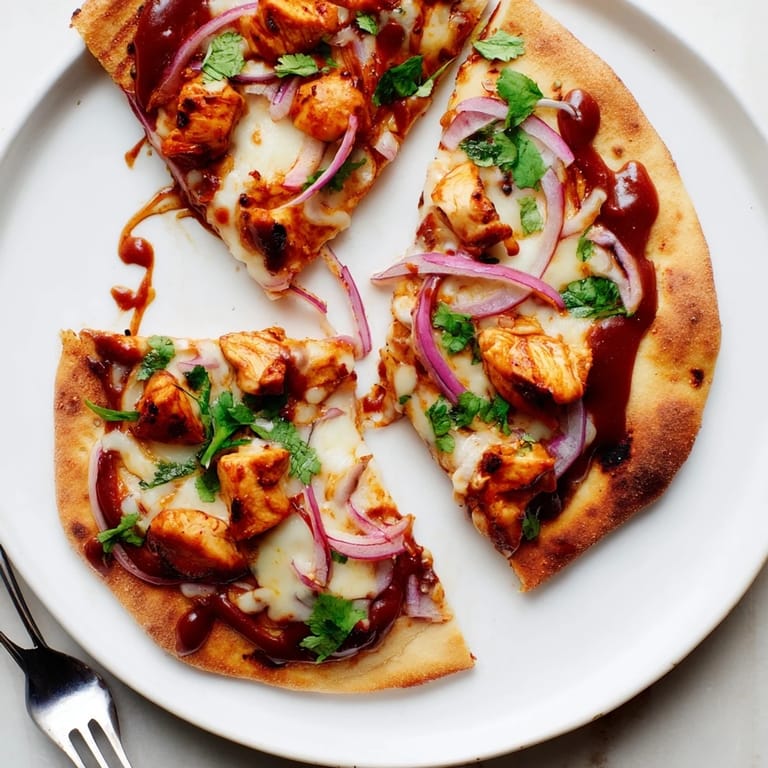 This easy BBQ Chicken Flatbread recipe features a golden-brown flatbread drizzled with tangy barbecue sauce and topped with fresh cilantro.