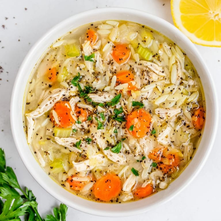 Comforting Lemon Pepper Chicken Orzo Soup in a white ceramic bowl, ready to serve on a chilly March evening.