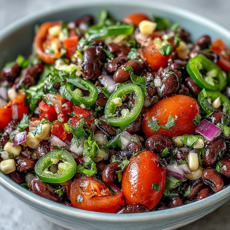 Freshly tossed Tex-Mex Cowboy Caviar salad with black-eyed peas and tomatoes, ready to serve as a vibrant party appetizer or side.