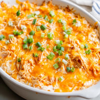 Golden, bubbly Buffalo Chicken Dip served with crisp celery and crunchy tortilla chips.