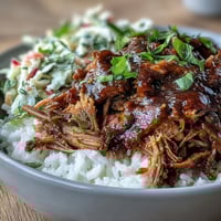 Tender shredded pork and crisp coleslaw on fluffy rice in a hearty pulled pork bowl.